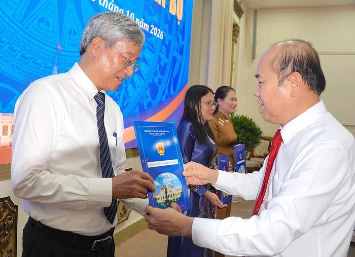 Phó Chủ tịch UBND TPHCM Trần Văn Bảy trao quyết định điều động ông Phạm Bình An giữ chức Phó Chánh Văn phòng UBND TPHCM. Ảnh: Quang Huy