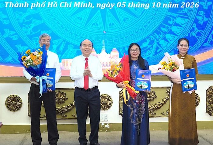 Lãnh đạo UBND TPHCM trao quyết định và hoa chúc mừng các cán bộ được điều động nhận nhiệm vụ mới. Ảnh: Quang Huy