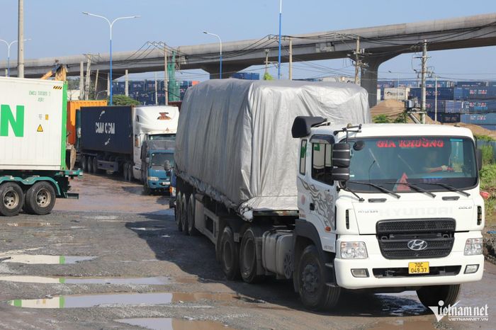 Đoàn xe tải nặng nối đuôi nhau bò qua đoạn đường xuống cấp, đọng nước tại nút giao Tân Vạn. Ảnh: TK 