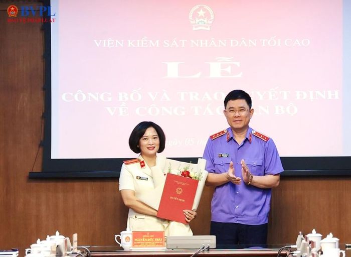 Đồng chí Nguyễn Đức Thái, Phó Viện trưởng VKSND tối cao trao Quyết định và tặng hoa chúc mừng đồng chí Nguyễn Thị Nga.