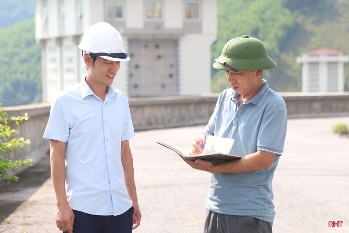Ông Lê Văn Kiên - Giám đốc Chi nhánh Ngàn Trươi (bên trái) trao đổi với cán bộ kĩ thuật về mực của hồ Ngàn Trươi hiện tại và công tác vận hành trong thời gian tới.