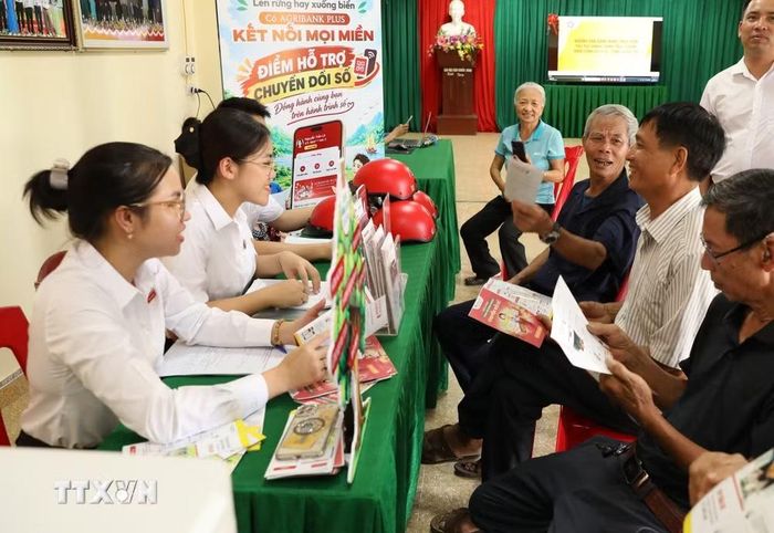 Người dân được giải đáp nhiều thắc mắc liên quan đến sử dụng tài khoản ngân hàng tại Điểm chuyển đổi số số 1 xã Gia Trấn, tỉnh Ninh Bình. (Ảnh: Đức Phương/TTXVN)