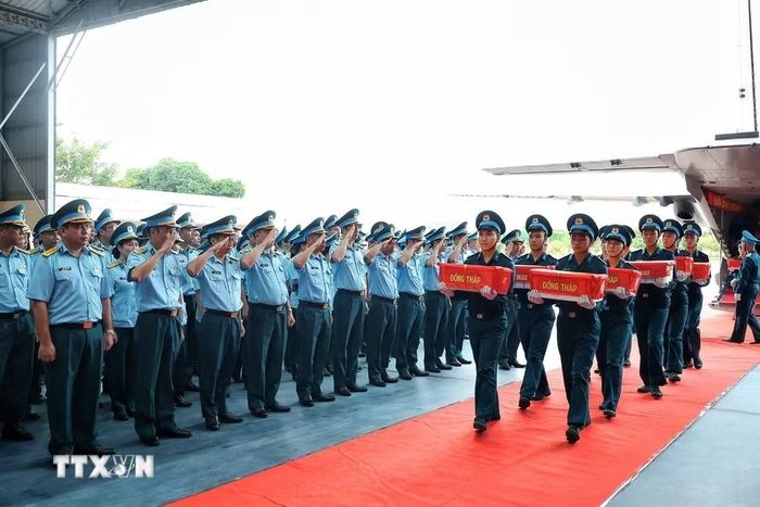 Cán bộ, chiến sỹ Quân chủng Phòng không - Không quân thực hiện nghi thức chào khi các mẫu sinh phẩm hài cốt liệt sỹ của các địa phương thuộc Quân khu 9 được đưa khỏi máy bay tại sân bay quân sự Gia Lâm. (Ảnh: Phạm Tuấn Anh/TTXVN)