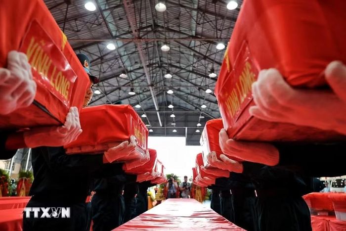 Cán bộ, chiến sỹ nâng niu, sắp đặt các thùng chứa mẫu sinh phẩm hài cốt liệt sỹ trước khi bàn giao cho Viện Pháp y Quân đội, Bộ Quốc phòng để phục vụ giám định ADN. (Ảnh: Phạm Tuấn Anh/TTXVN)