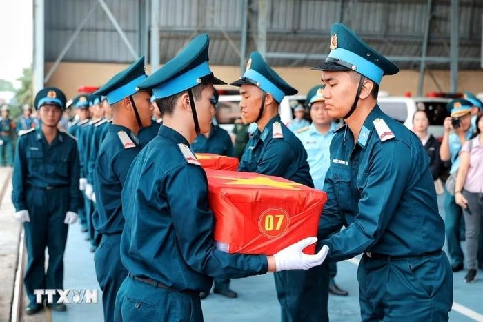 Cán bộ, chiến sỹ tiếp nhận các thùng chứa mẫu sinh phẩm hài cốt liệt sỹ sau khi được vận chuyển bằng máy bay quân sự từ Cần Thơ ra Hà Nội. (Ảnh: Phạm Tuấn Anh/TTXVN)