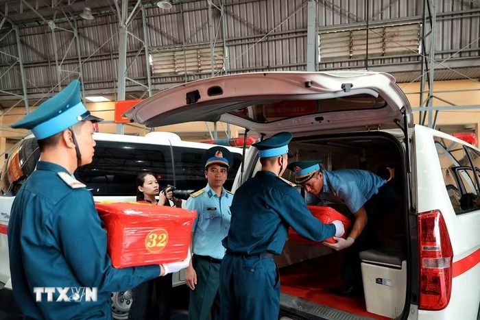 Cán bộ, chiến sỹ chuyển các thùng chứa mẫu sinh phẩm hài cốt liệt sỹ lên xe chuyên dụng để vận chuyển tới Viện Pháp y Quân đội, phục vụ giám định ADN. (Ảnh: Phạm Tuấn Anh/TTXVN)