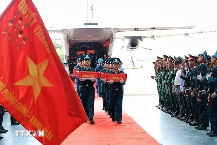 Các thùng chứa mẫu sinh phẩm hài cốt liệt sỹ được đưa từ máy bay vận tải quân sự xuống khu vực tiếp nhận tại sân bay quân sự Gia Lâm. (Ảnh: Phạm Tuấn Anh/TTXVN)