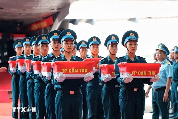 Các thùng chứa mẫu sinh phẩm hài cốt liệt sỹ được đưa ra khỏi máy bay để thực hiện quy trình tiếp nhận, bàn giao. (Ảnh: Phạm Tuấn Anh/TTXVN)