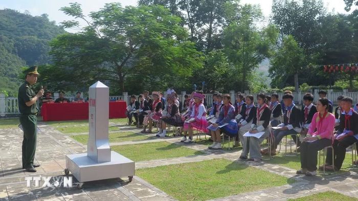 Giới thiệu về cột Mốc quốc giới 92 cho học sinh (sử dụng mô hình cột mốc). (Ảnh: Hương Thu/TTXVN)