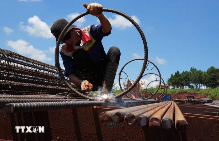 Một công nhân cho biết việc thi công cột khung cốt thép được tăng tốc cả khi trời nắng và trời mưa để đẩy nhanh tiến độ cho công trình. (Ảnh: Nguyễn Dũng/TTXVN)
