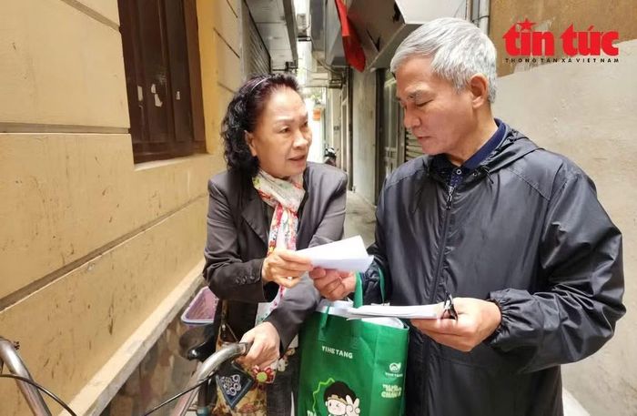 Cán bộ tổ dân phố của phường Giảng Võ phát thẻ cử tri cho người dân trước ngày bầu cử đại biểu Quốc hội và HĐND các cấp.
