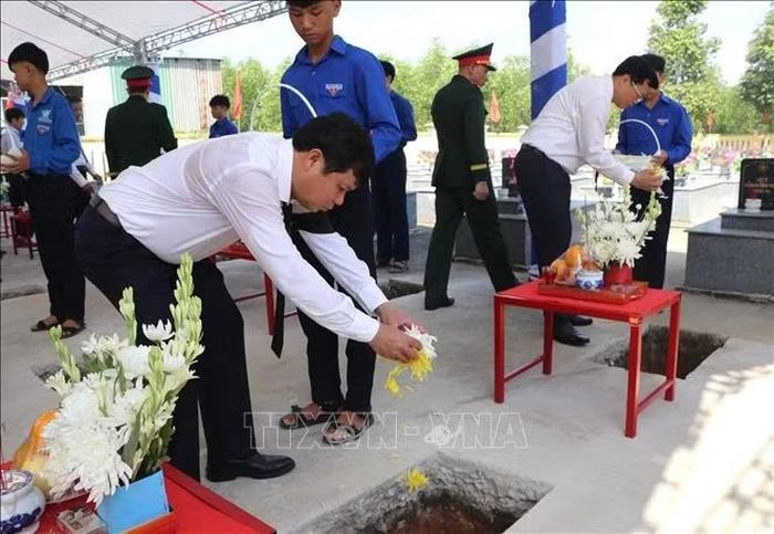 Các đồng chí lãnh đạo thả hoa xuống phần mộ liệt sĩ, tiễn các anh về nơi an nghỉ.