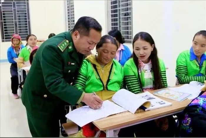 Cán bộ Đồn Biên phòng Quang Chiểu tận tình xóa mù chữ cho phụ nữ vùng cao biên giới. Ảnh: TTXVN phát