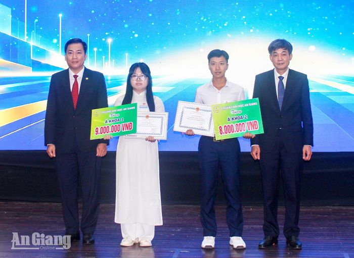 Hồ Ngọc Yến Oanh (thứ hai, từ trái qua) và Nguyễn Quốc Anh Hào (thứ ba, từ trái qua) nhận học bổng á khoa 1 và á khoa 2 của Trường Đại học An Giang.