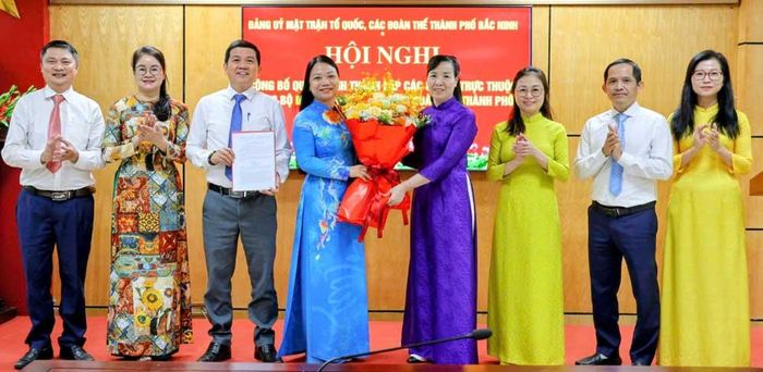 Đồng chí Nguyễn Thị Hà trao Quyết định và tặng hoa chúc mừng Chi bộ Cơ quan Ủy ban MTTQ thành phố.