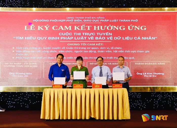Đại diện lãnh đạo các đơn vị liên quan ký cam kết hưởng ứng cuộc thi trực tuyến “Tìm hiểu quy định pháp luật về bảo vệ dữ liệu cá nhân”. Ảnh: QUỐC TUẤN