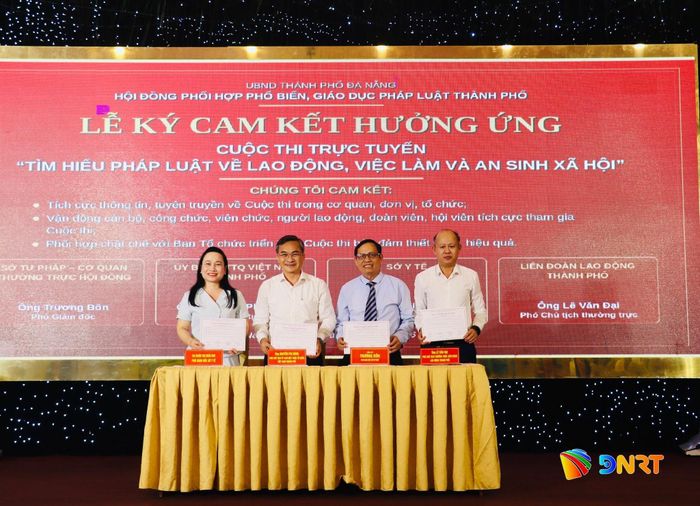 Đại diện lãnh đạo các đơn vị liên quan ký cam kết hưởng ứng cuộc thi trực tuyến “Tìm hiểu pháp luật về lao động, việc làm và an sinh xã hội”. Ảnh: QUỐC TUẤN