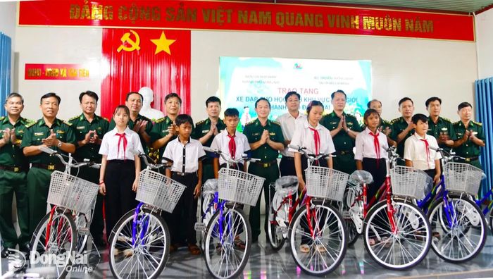 Thủ trưởng Ban Chỉ huy Bộ đội Biên phòng thành phố, lãnh đạo xã Tân Tiến và các trường trao tặng xe đạp cho học sinh. Ảnh: Hữu Thịnh