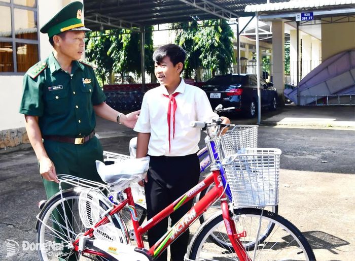 Chỉ huy Đồn Biên phòng Cửa khẩu quốc tế Hoa Lư đưa học sinh đến nhận xe đạp. Ảnh: Hữu Thịnh