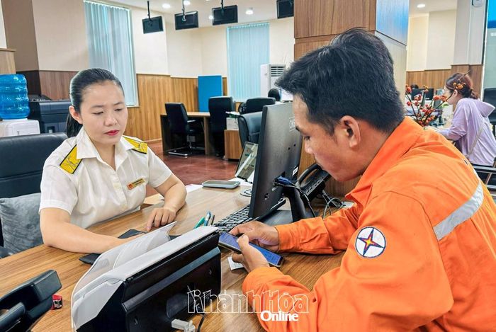 Cán bộ thuế hướng dẫn người dân cài đặt ứng dụng eTax Mobile.