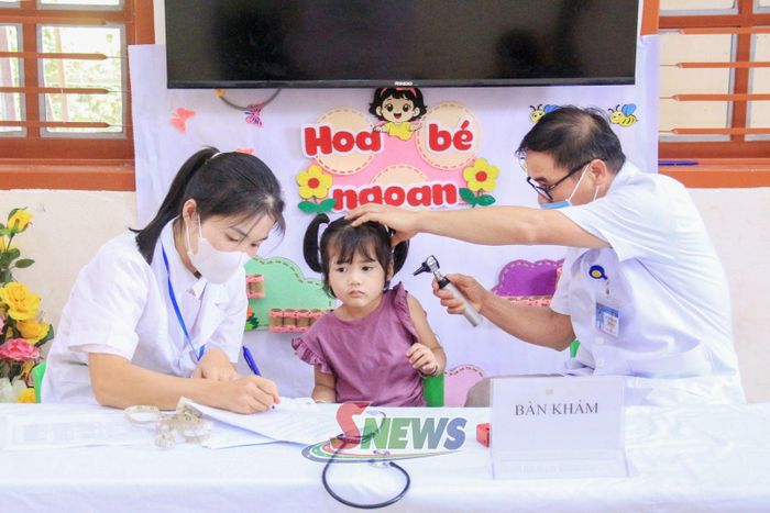 Cán bộ Trạm Y tế xã Quỳnh Nhai kiểm tra sức khỏe cho trẻ mầm non.