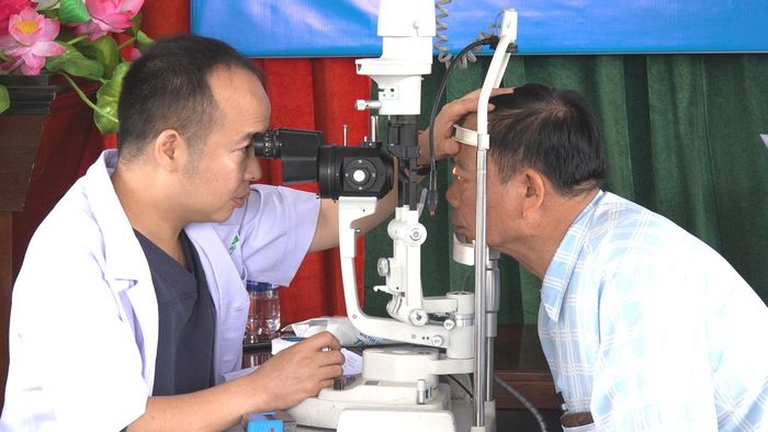 Bác sĩ khám mắt cho người dân trong chương trình khám sức khỏe định kỳ.