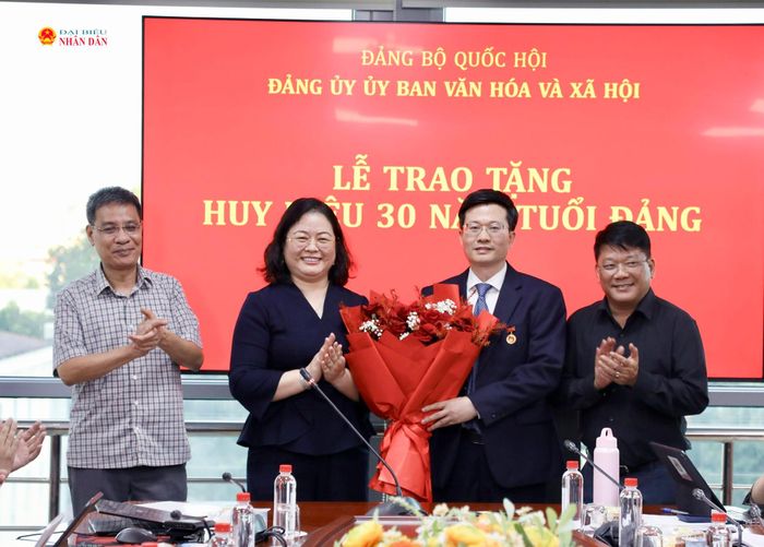 Các đại biểu tặng hoa chúc mừng đồng chí Đỗ Chí Nghĩa