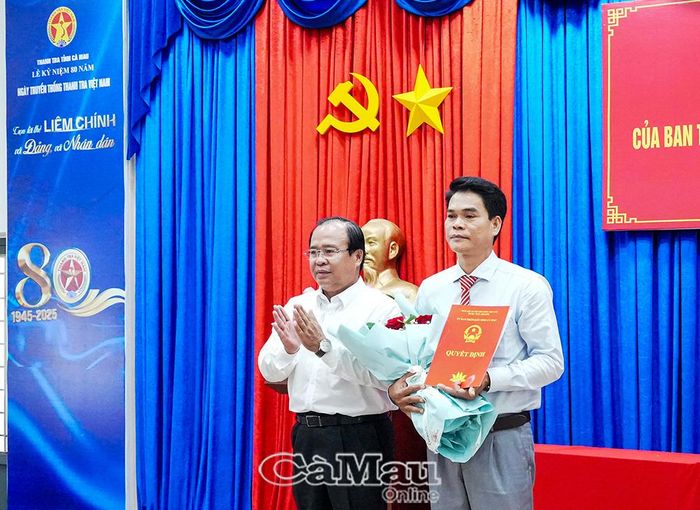 Phó Chủ tịch UBND tỉnh Nguyễn Minh Luân trao quyết định và tặng hoa chúc mừng đồng chí Nguyễn Văn Phụng.