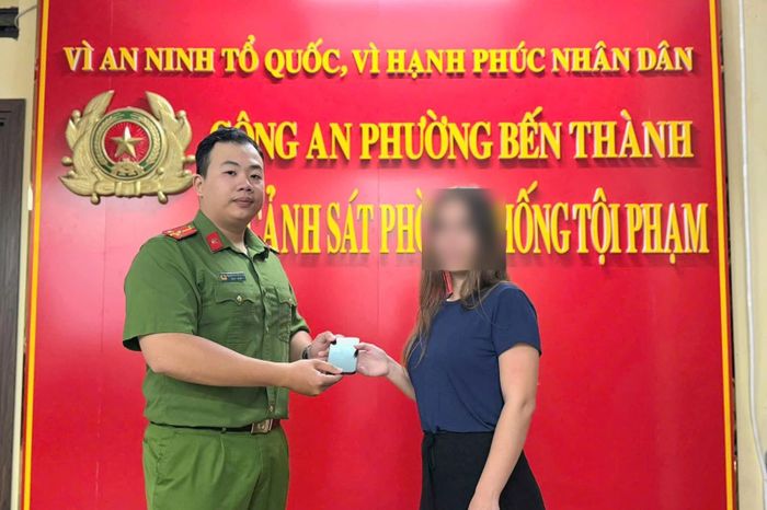 Cán bộ Công an phường Bến Thành trao trả chiếc điện thoại cho nữ du khách bị cướp giật gần chợ Bến Thành sáng 01/10