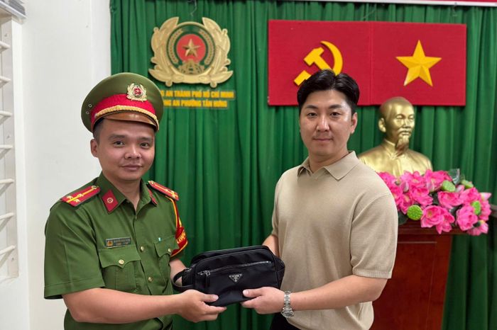 Cán bộ Công an phường Tân Hưng trao trả chiếc túi xách cho ông Lee Jae Young sau 3 giờ tiếp nhận tin báo