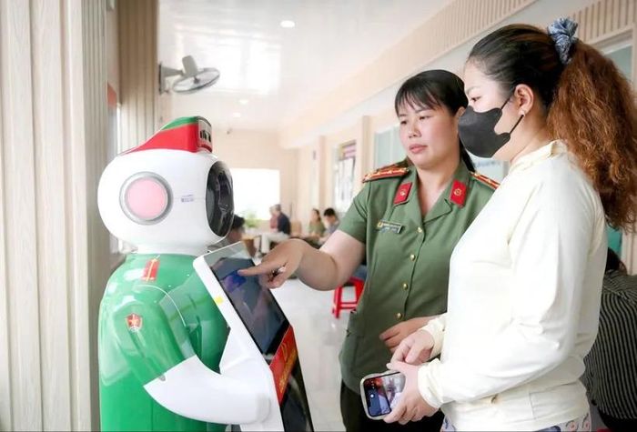 Công an xã Đông Thạnh hướng dẫn người dân tương tác với robot lễ tân