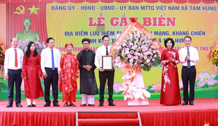 Phó Bí thư Thành ủy, Chủ tịch HĐND thành phố Hà Nội Phùng Thị Hồng Hà trao Quyết định gắn biển Di tích cách mạng kháng chiến Đình Kim tới cán bộ và nhân dân xã Tam Hưng. Ảnh: Văn Tuyến 