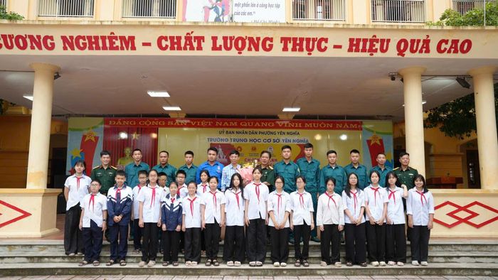 Học sinh Trường THCS Yên Nghĩa chụp ảnh lưu niệm cùng các thầy, cô giáo và đại diện Ban Chỉ huy Quân sự phường Yên Nghĩa. Ảnh: Phương Thanh