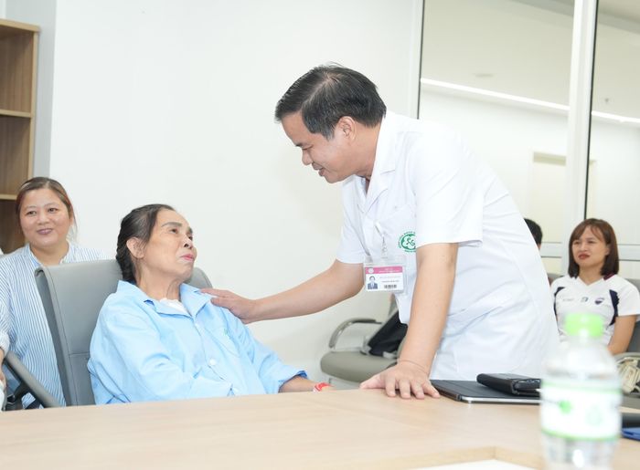 PGS.TS Đào Xuân Cơ - Giám đốc Bệnh viện Bạch Mai trò chuyện với nữ bệnh nhân Vũ Thị Yêu - người bị vỡ tim đã được các bác sĩ Bạch Mai nỗ lực cứu sống tại cơ sở Ninh Bình.. Ảnh: Thành Dương