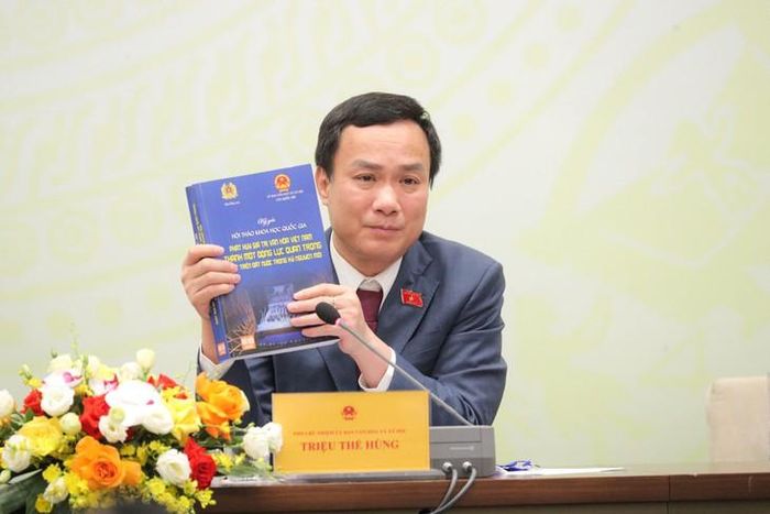 Phó Chủ nhiệm Ủy ban Văn hóa và Xã hội Triệu Thế Hùng giới thiệu về cuốn kỷ yếu tại Hội thảo. Ảnh: LB