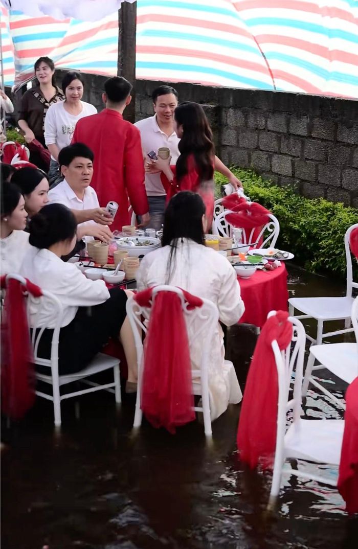 Quan khách cùng dâu rể xắn quần, co chân ngồi ăn cỗ.