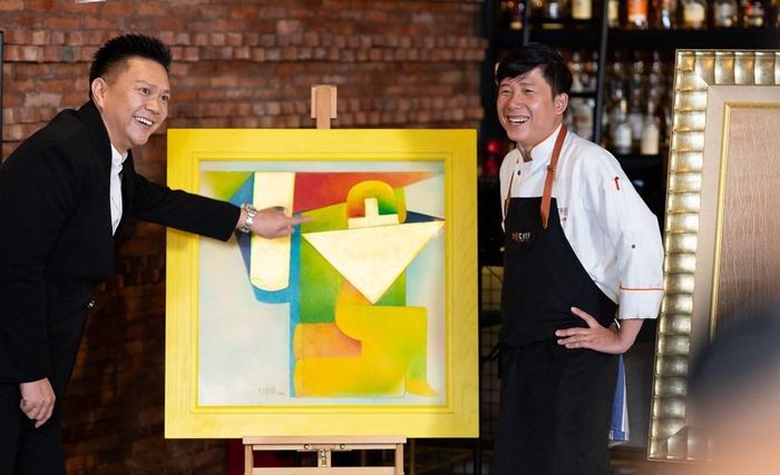 Đầu bếp Khắc Linh và giám khảo Valentin Trần bên tác phẩm “Mục đồng chăn trâu” của họa sĩ Thành Chương