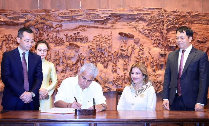 Tổng thống Cộng hòa Panama José Raúl Mulino và Phu nhân viết lưu bút tại khu Văn Miếu - Quốc Tử Giám. Ảnh: Tuấn Anh - TTXVN