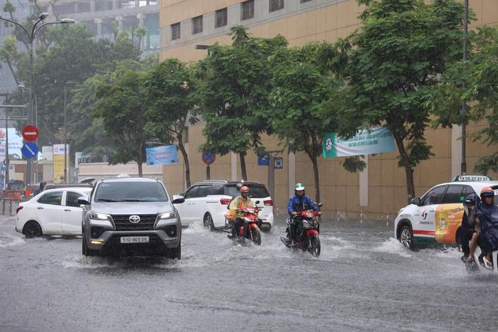 Các phương tiện lưu thông trên đường Lê Lợi bị ngập sâu, trưa 6/10. Ảnh: Hồng Đạt - TTXVN