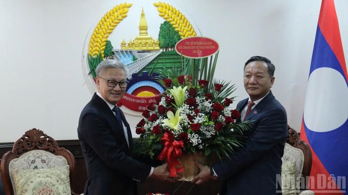 Đại sứ Nguyễn Minh Tâm chuyển lẵng hoa của Bộ trưởng Lê Hoài Trung chúc mừng Phó Thủ tướng, Bộ trưởng Ngoại giao Lào Thongsavanh Phomvihane. (Ảnh: DUY TOÀN)