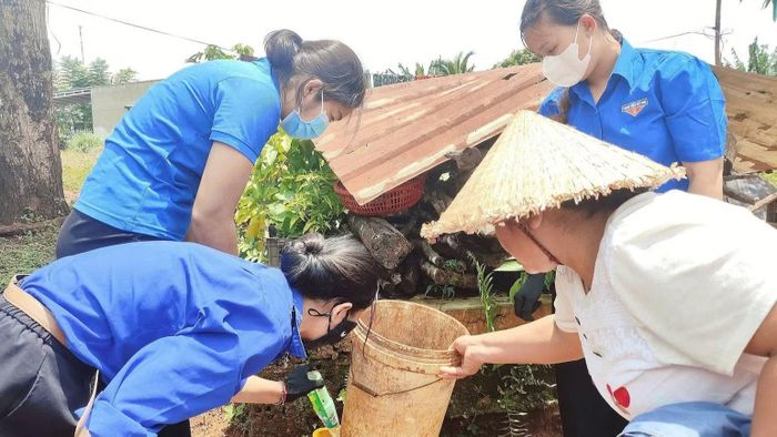 Đoàn viên thanh niên cùng người dân lật úp các vật dụng chứa nước không dùng đến để ngăn muỗi vằn đẻ trứng và phòng, chống sốt xuất huyết. (Ảnh: NS)