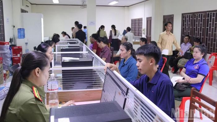 Cán bộ Cục Quản lý hộ tịch và xây dựng cơ sở, Bộ Công an Lào, hướng dẫn người dân Lào làm thủ tục căn cước công dân. (Ảnh: DUY TOÀN)