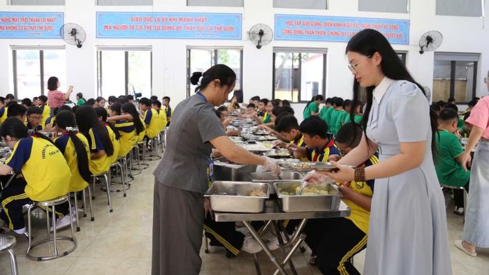 Tại nhiều trường học, bữa ăn có sự giám sát, hỗ trợ của phụ huynh học sinh. (Ảnh: A.T)