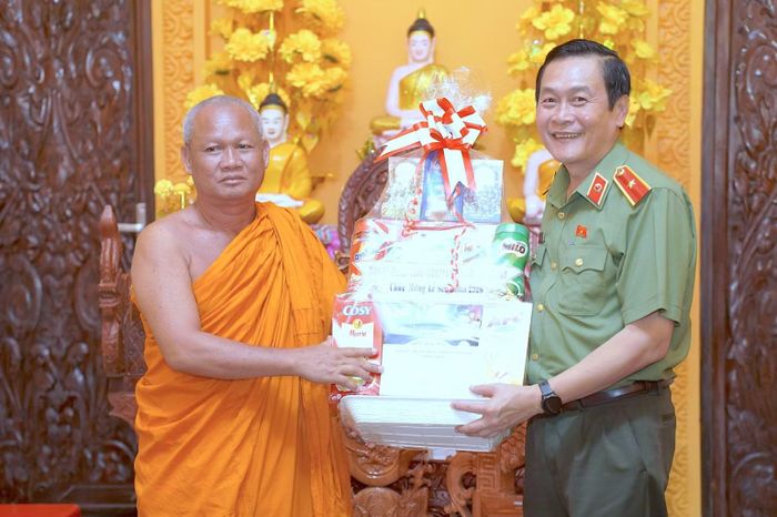 Thiếu tướng Hồ Việt Triều (bên phải) thay mặt lãnh đạo tỉnh tặng phần quà đến Thượng tọa Trần Duyên, Trụ trì Chùa Kosthum, xã Ninh Thạnh Lợi. (Ảnh: HỮU ĐỆ)