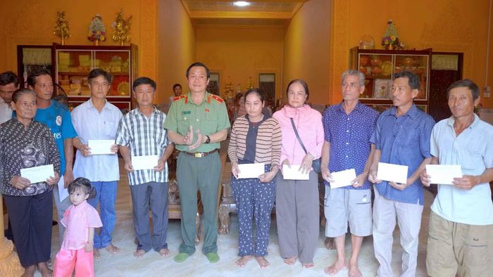 Tặng quà các gia đình chính sách trong đồng bào dân tộc Khmer xã Ninh Thạnh Lợi. (Ảnh: HỮU ĐỆ)