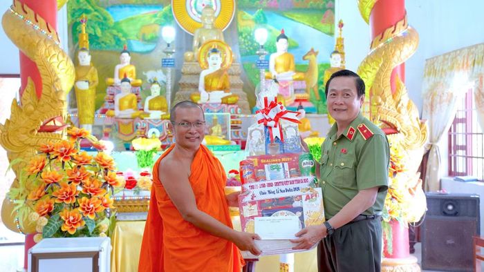 Thiếu tướng Hồ Việt Triều (bên phải) thay mặt lãnh đạo tỉnh Cà Mau tặng quà đến Thượng tọa Hồ Mít, Trụ trì chùa Dì Quán, xã Ninh Quới, tỉnh Cà Mau. (Ảnh: HỮU ĐỆ)