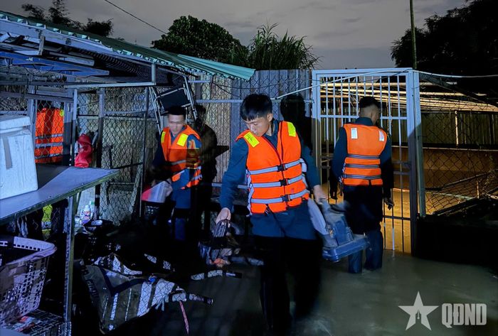  Lực lượng dân quân hỗ trợ di dời tài sản của người dân khu vực bị ngập sâu.