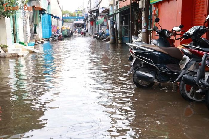 Một số gia đình phải dùng bao cát và các vật dụng tạm thời dựng thành “đê” trước cửa. Tuy nhiên, với những căn nhà có nền thấp hơn mặt đường, nước vẫn tràn vào.