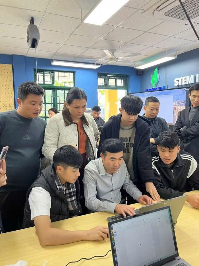 Ông Phạm Văn Hạ - Hiệu trưởng Trường PTDTNT THPT Mường Nhé (áo màu xám, ngồi giữa) cùng "lăn lộn" với học sinh trong giờ học.