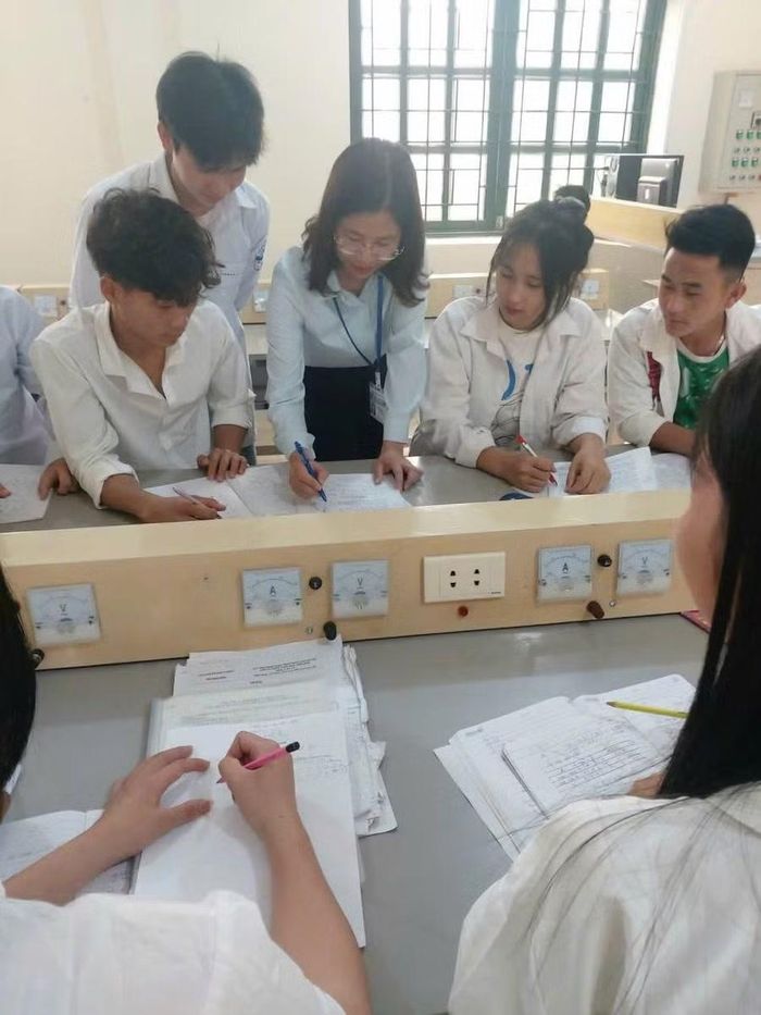 Cô Phạm Thị Tươi (áo màu xanh nhạt, đứng giữa) cùng học trò trong một tiết học.